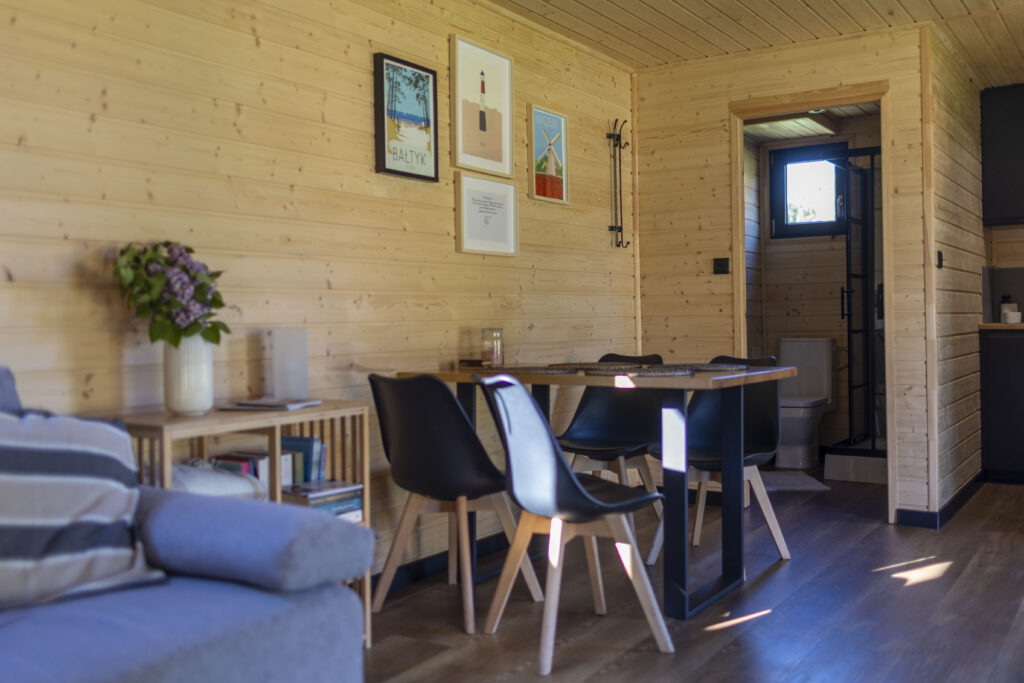 Stół czteroosobowy w salonie i wejście do toalety w Westfalowej Chatce.